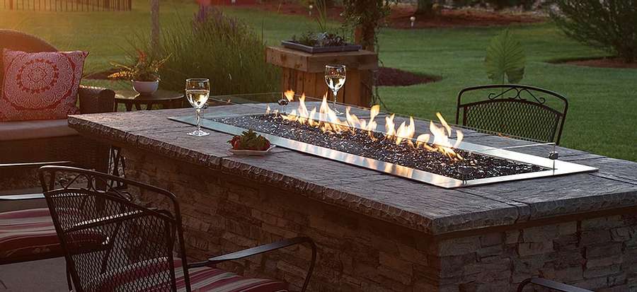 glass of wine and fruit next to a firepit